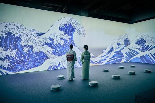 Deux visiteuses en kimono face à la projection monumentale de La Grande Vague d'Hokusai – exposition Passion Japon, La Villette