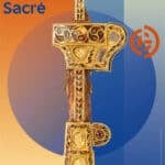 Poster for Guimet exhibition 'Silla: l’Or et le Sacré' showing a gilded ceremonial cross against an orange-to-blue gradient background.