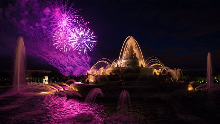 Feu d’artifice au-dessus d’un bassin en eau dans les jardins du Château de Versailles