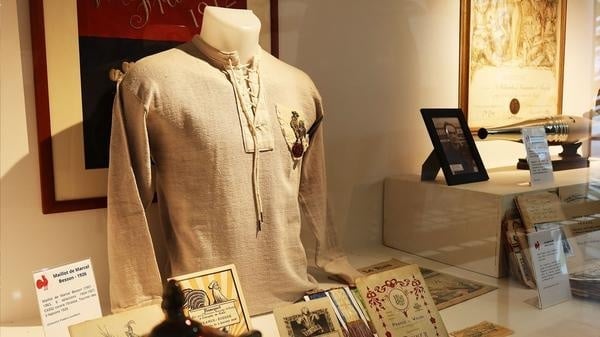 Maillots internationaux suspendus et vitrine de trophées dans le hall du Centre National de Rugby