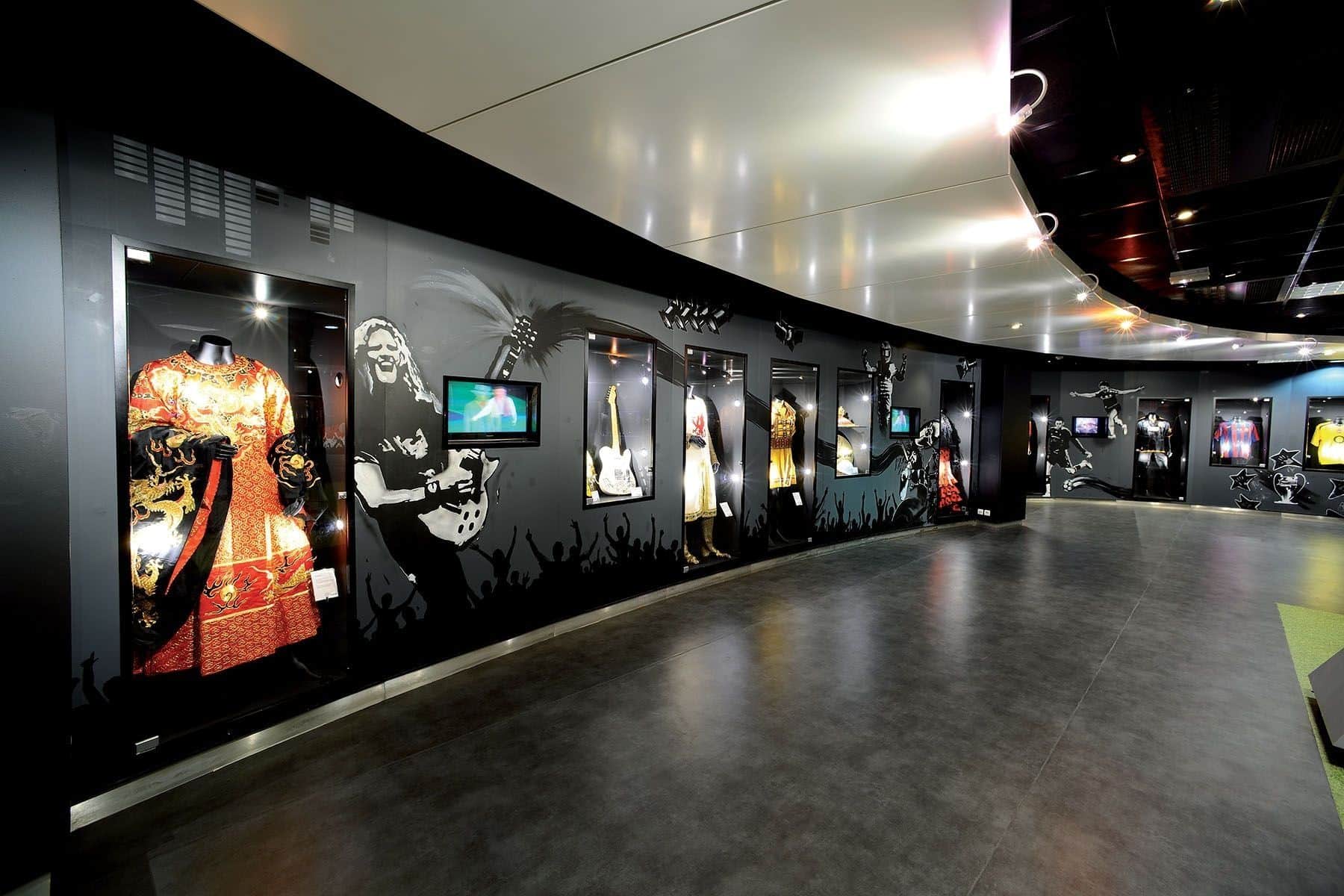 Costumes de scène, guitare et maillots de football dans les vitrines du musée du stade